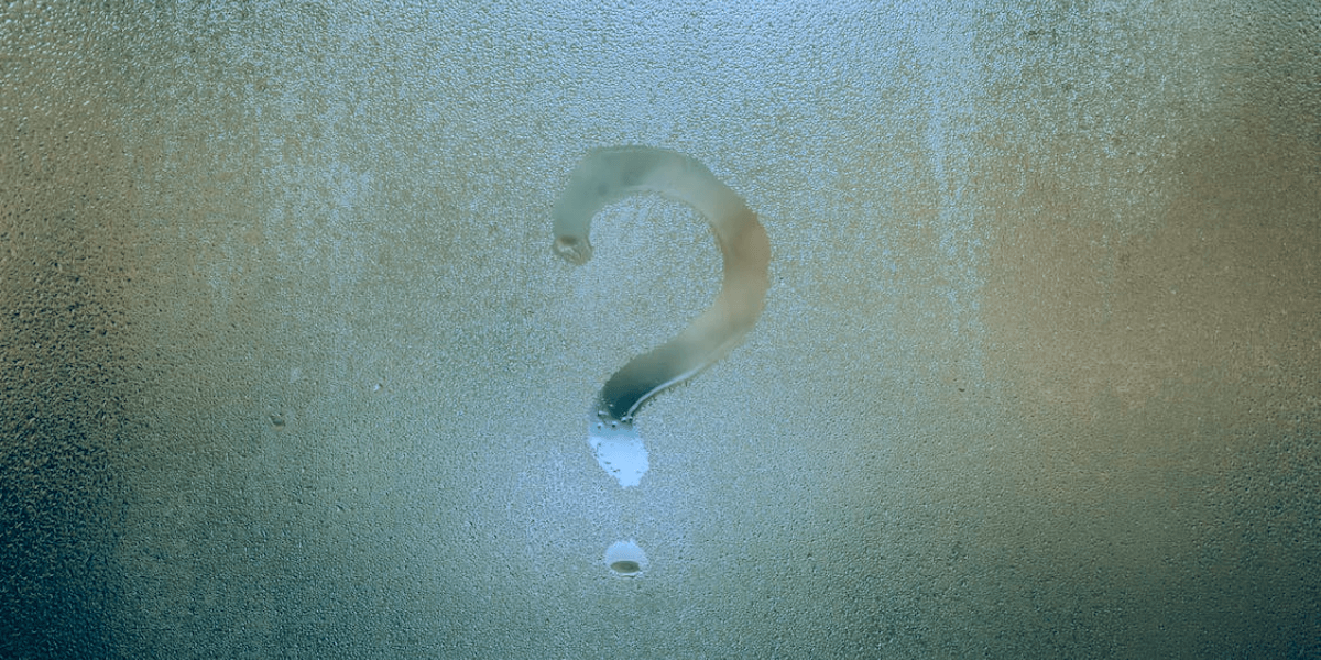 a question mark drawn on a vapourish window